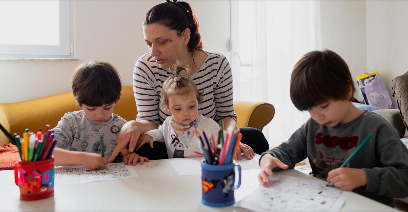 Parent oversees craft activity with children